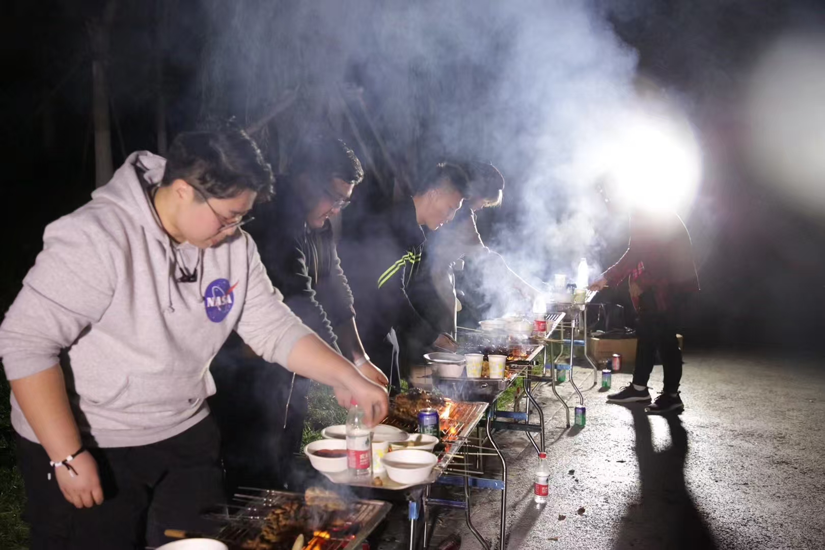 学员在夜间户外烧烤活动中交流
